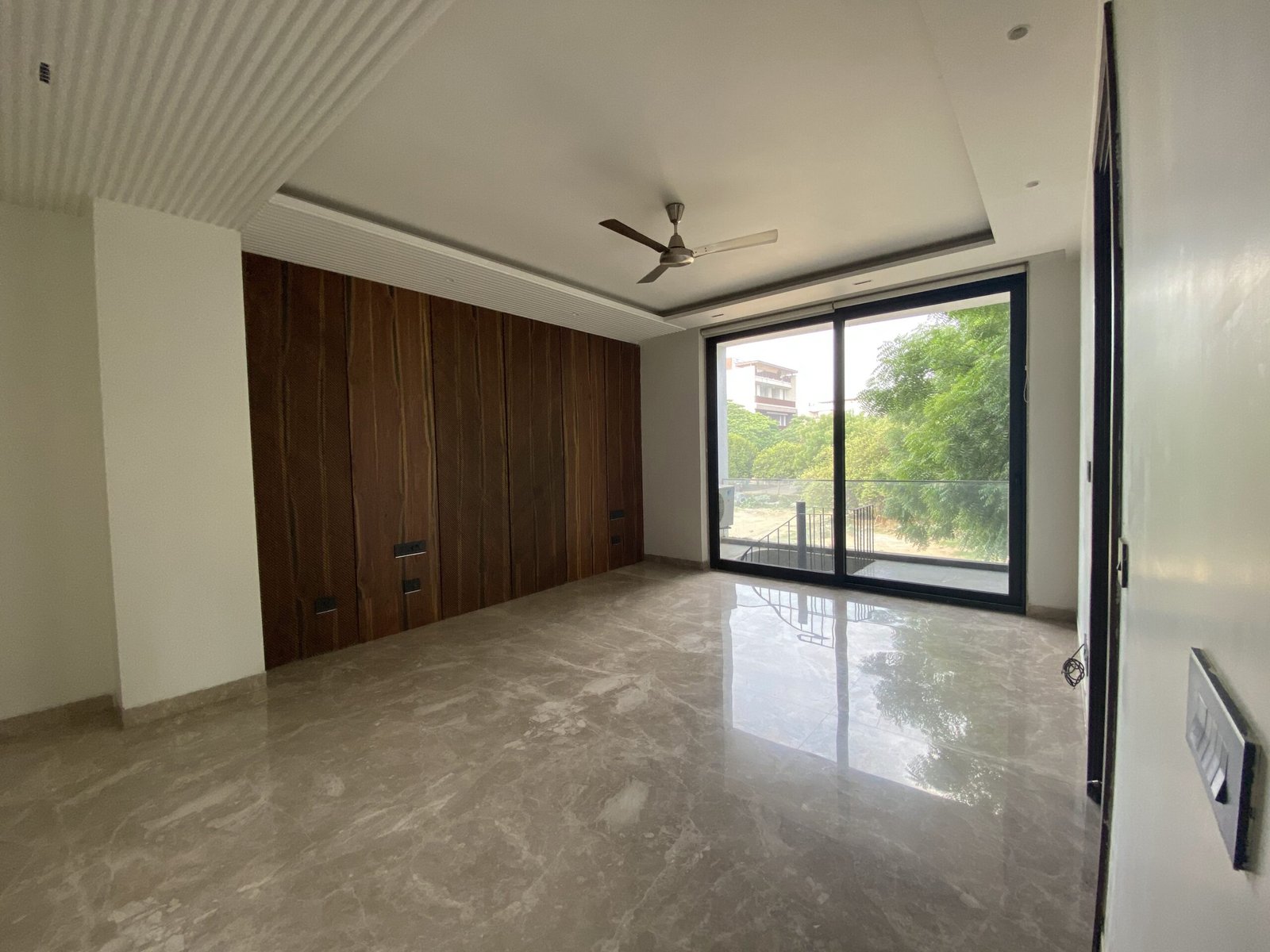 Spacious bedroom in a premium builder floor at Emerald Hills Sector 65 Gurgaon with balcony and luxury interiors